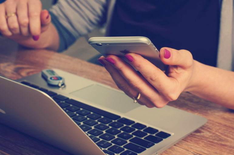 Woman with laptop and iphone